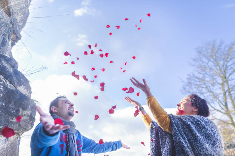 le photographe capte l'instant ou le couple lance les pétales de rose