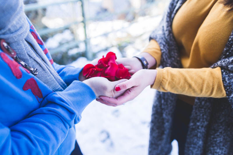 les futurs mariés tiennent des pétales de rose dans leurs mains